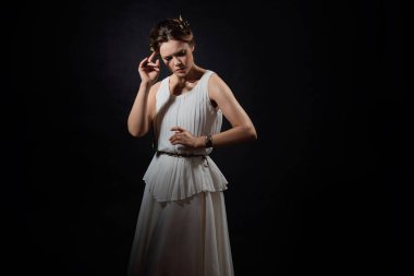 Antik Yunan tanrıçasının ya da ilham perisinin suretinde genç bir kadın..