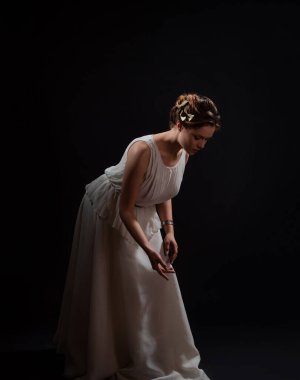 Antik Yunan tanrıçasının ya da ilham perisinin suretinde genç bir kadın..