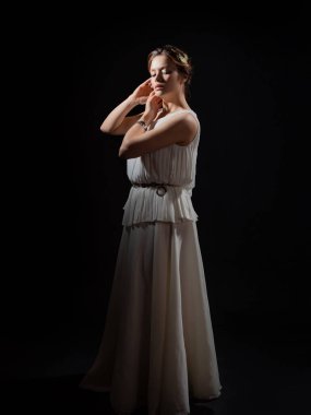 Antik Yunan tanrıçasının ya da ilham perisinin suretinde genç bir kadın..