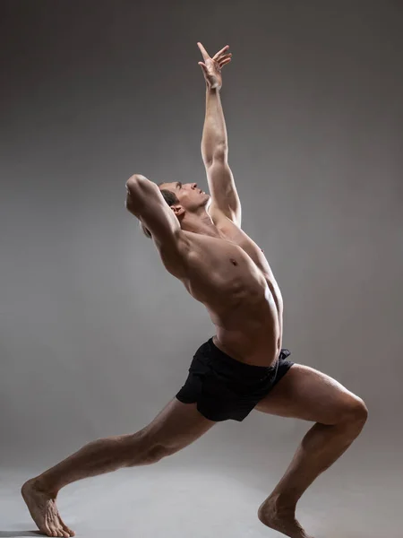 Um jovem homem musculoso em uma pose expressiva. Belos músculos. — Fotografia de Stock