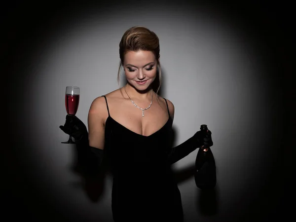 A beautiful woman in a black dress with a neckline and long velvet gloves, — Fotografia de Stock