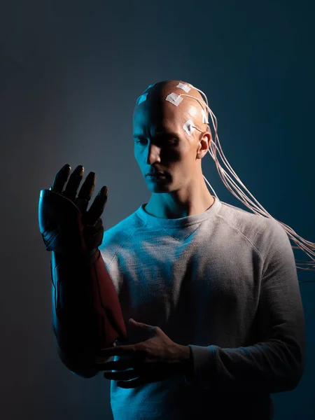 Mladý muž s hlavou propletenou dráty a robotickou paží, — Stock fotografie