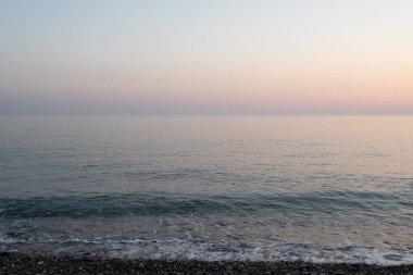 Ufukta gökyüzü ve denizin birleşimi, sakin deniz, rahatlatıcı güzel manzara.