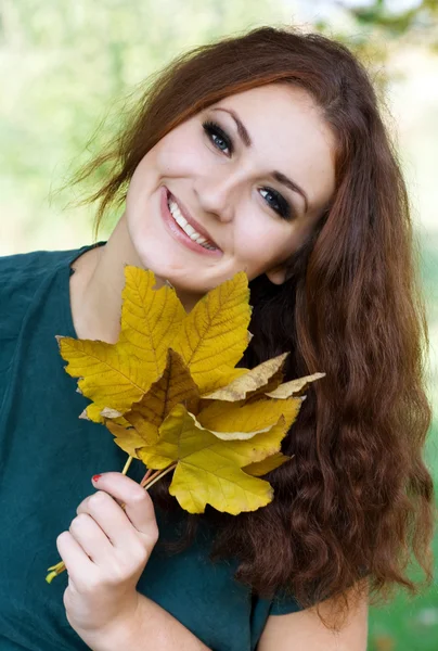 Femme tenant une feuille d'automne jaune — Photo