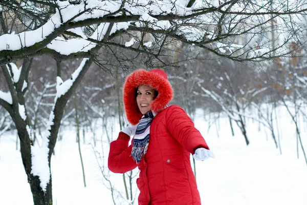 Winter girl throwing snowball at camera smiling happy having fun — Stock Photo, Image