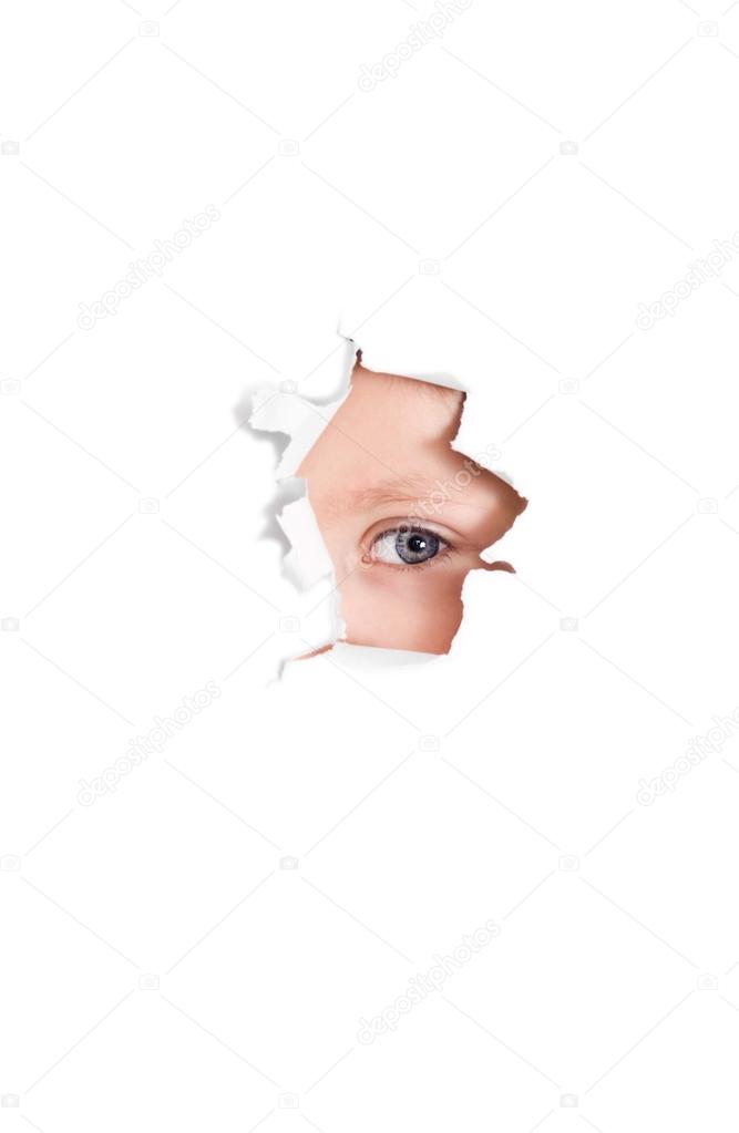 Cute baby girl looking through paper hole