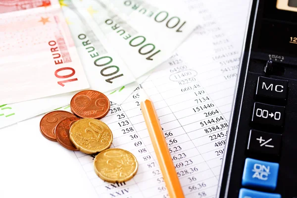 Калькулятор, монеты и банкнота в 100 евро — стоковое фото