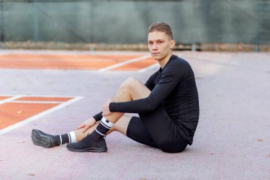 Yakışıklı genç adam fiziksel aktiviteden sonra dinleniyor.