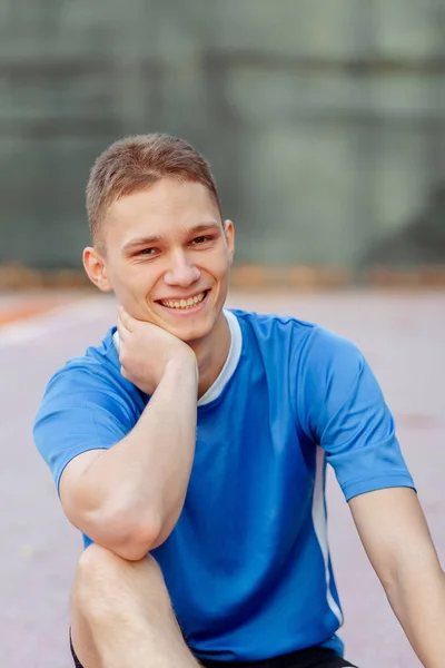 Jonge Sportieve Man Die Het Sportveld Zit Glimlacht Terwijl Hij — Stockfoto