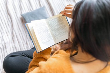 Evde kitap okuyan kıdemli bir kadın. Yakın çekim.