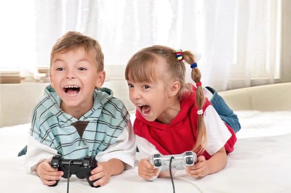 Happy girl and boy playing a video game — Stock Photo, Image