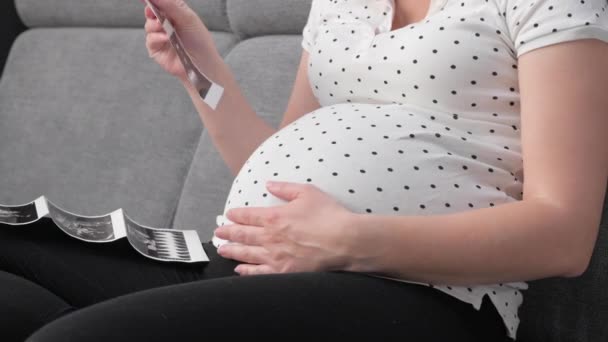 Schwangere auf Sofa mit Ultraschallbild — Stockvideo