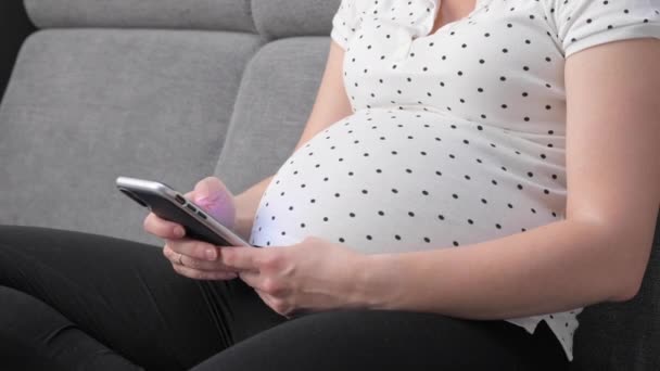 Femme enceinte sur canapé en utilisant le téléphone — Video