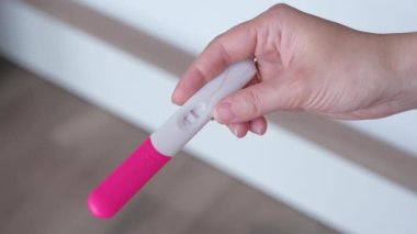 Hamilelik testi tutan kadın eller. Test yapan kadın - sonuç pozitif, iki çizgi göster. Hamilelik konsepti, aile planlaması.