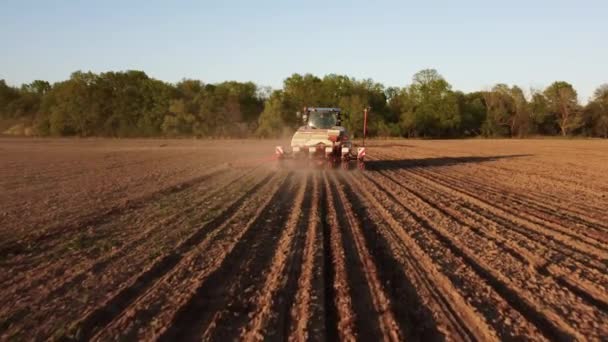 春のフィールドでの作業で青トラクターの空中ビュー 播種の準備時間 植え付けのための準備された土壌でフィールドにトラクターの上を飛んで無人機から撮影 農業の概念 田園風景 — ストック動画