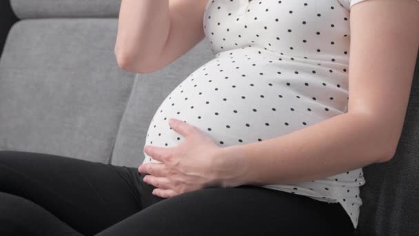 孕妇坐在家里的沙发上 手里拿着一个绿色的苹果 一个鲜果未被承认的女孩怀孕 健康饮食和孕产概念 — 图库视频影像