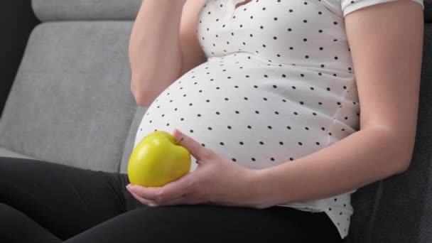 Pregnant Woman Holding Eating Green Red Apples While Sitting Sofa — Video