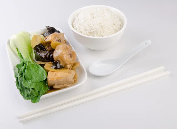 Курица с рисом и овощами на заднем плане — стоковое фото
