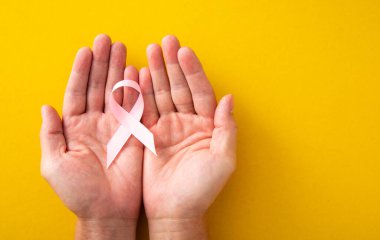 Göğüs kanseri kavramı: Kadın elleri ve göğüs kanserinin destekleyici pembe kurdele sembolü