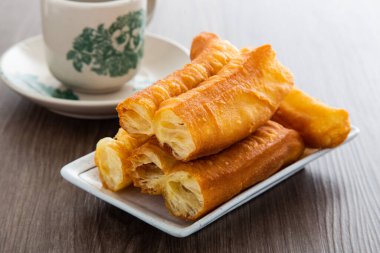 Youtiao (Çin usulü kızarmış ekmek). Uzun altın sarısı kızarmış hamur şeridi.