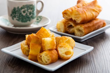 Youtiao (Çin usulü kızarmış ekmek). Uzun altın sarısı kızarmış hamur şeridi.