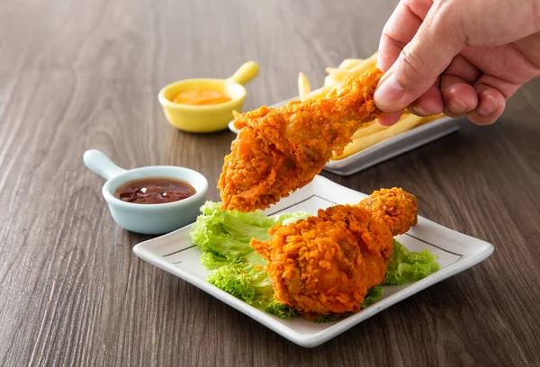 Mano Sosteniendo Pollos Fritos Crujientes Dorados Con Salsa Mesa Madera — Foto de Stock