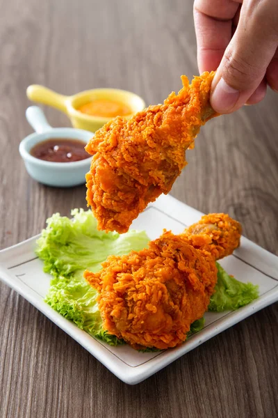 Mão Segurando Galinhas Fritas Crocantes Douradas Com Molho Mesa Madeira — Fotografia de Stock