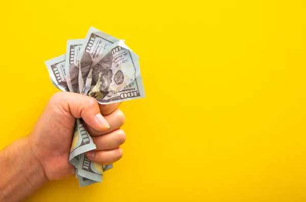 Male Hand Squeezing Tightly Some Banknote Yellow Background — Stockfoto
