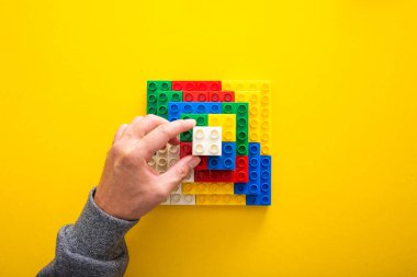 Renkli plastik blokları üst üste diziyorum.