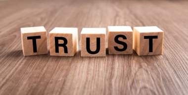 Wooden blocks with the word Trust. Trust relationships between business partners, friend and relatives.