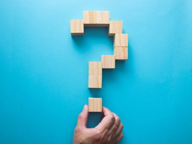 Hand forming a question marks symbol, financial business concept, blue background