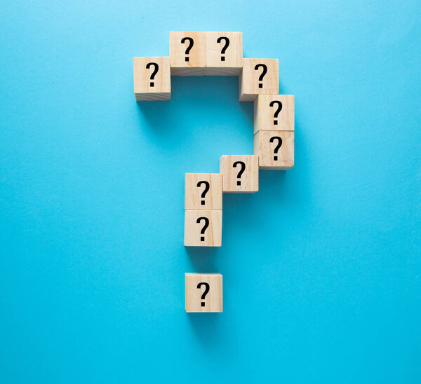 Question marks on wooden blocks, financial business concept, blue background