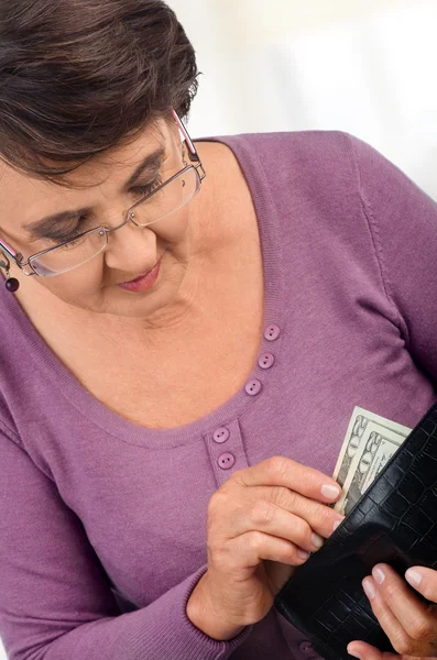 Elderly woman holding wallet with money — Stock Photo, Image