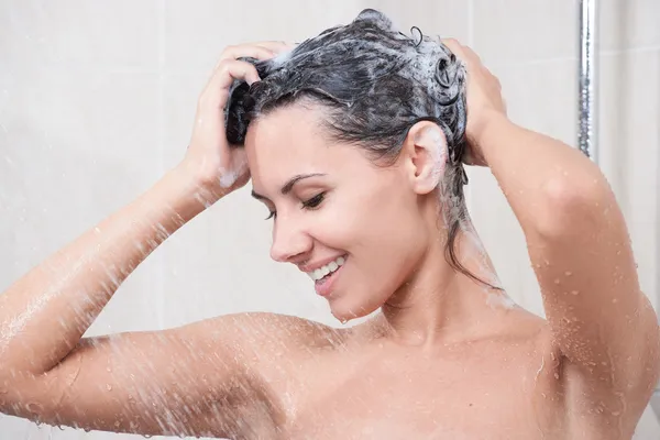 Młoda kobieta przez szampon do mycia głowy — Zdjęcie stockowe