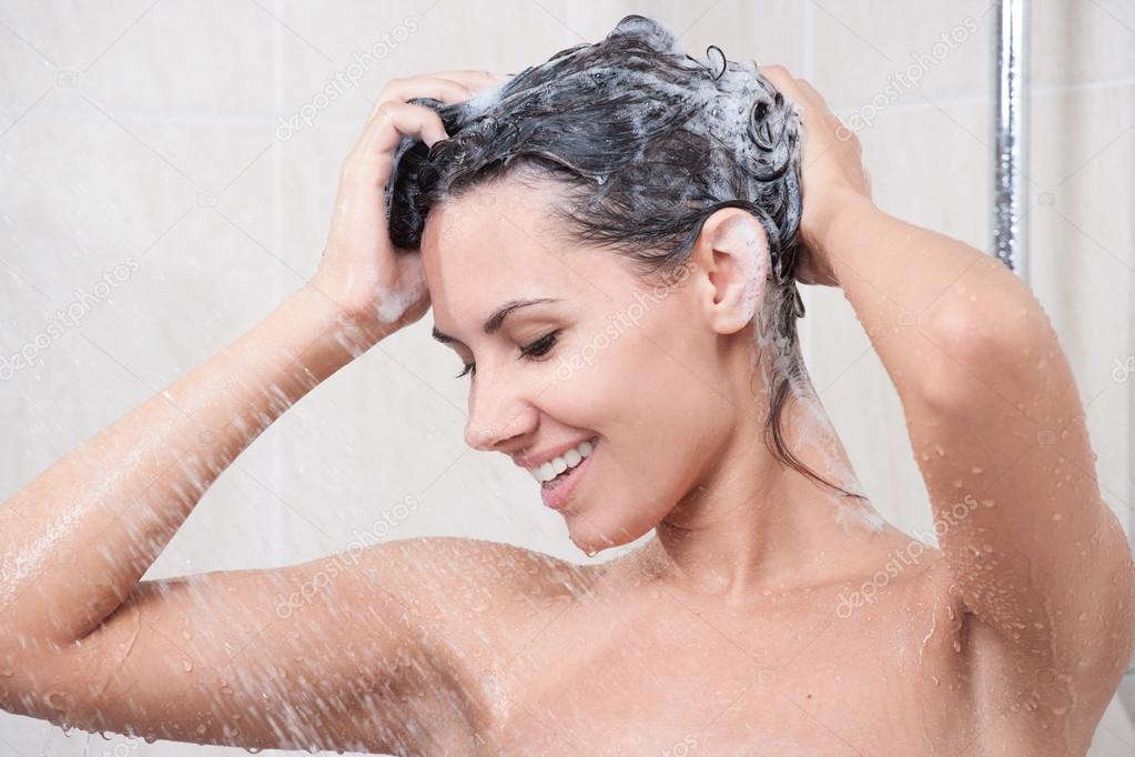 Young woman washing head by shampoo
