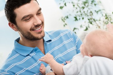 bir bebekle oynarken mutlu baba