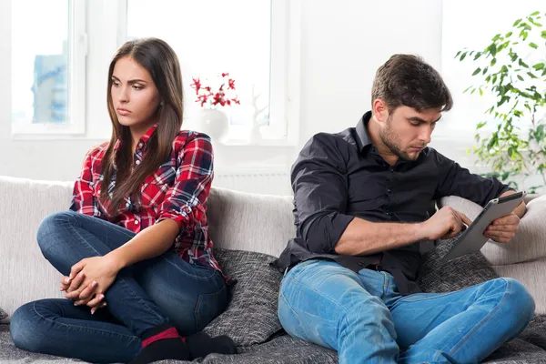 Jovem casal em conflito, um cara com um tablet — Fotografia de Stock