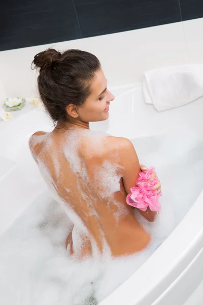 Hermosa mujer joven tomando un baño de burbujas — Foto de Stock