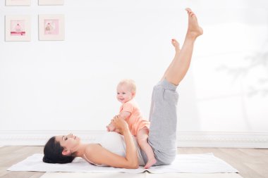 Annenin bebeği ile jimnastik yaptığı