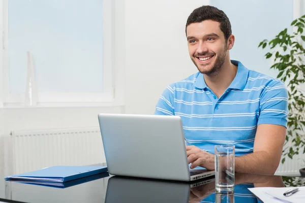 Happy businesswoman sitting at table with laptop — Stock Photo, Image