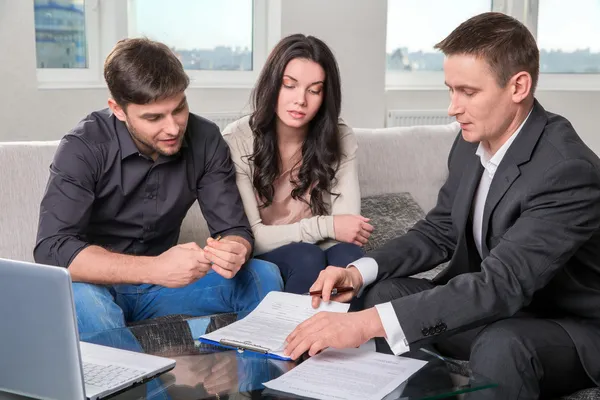 Agent advises the couple, signing documents — Stock Photo, Image