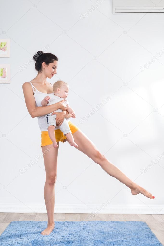 Mother does gymnastics with her baby