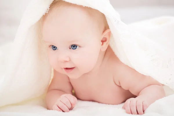 Baby onder een witte deken — Stockfoto