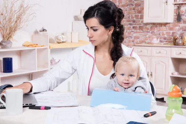 Kvinna med baby arbeta hemifrån — Stockfoto