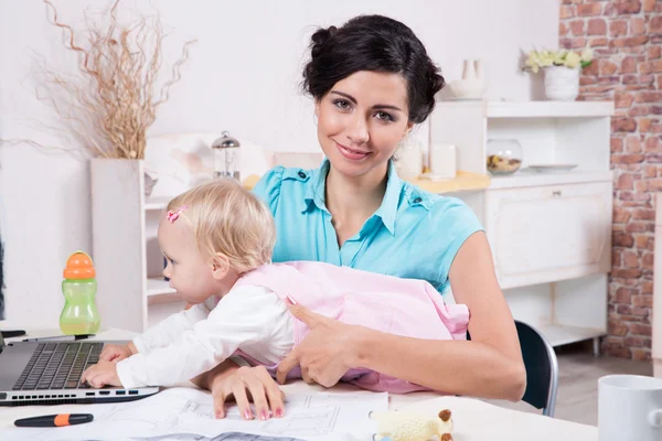 Femme d'affaires avec ordinateur portable et son bébé fille — Photo