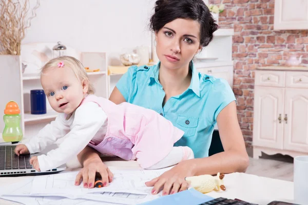 Femme d'affaires avec ordinateur portable et son bébé fille — Photo