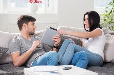 tablet bilgisayarlar ile bir kanepede oturan Çift