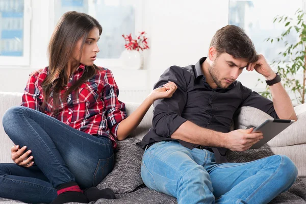 Jovem casal em conflito, um cara com um tablet — Fotografia de Stock