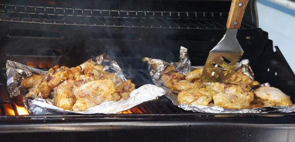 Tandoori chicken cooking on grill