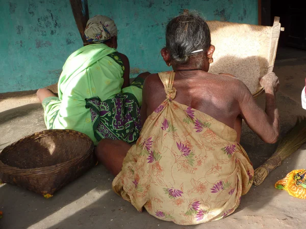 Old village women thresh rice